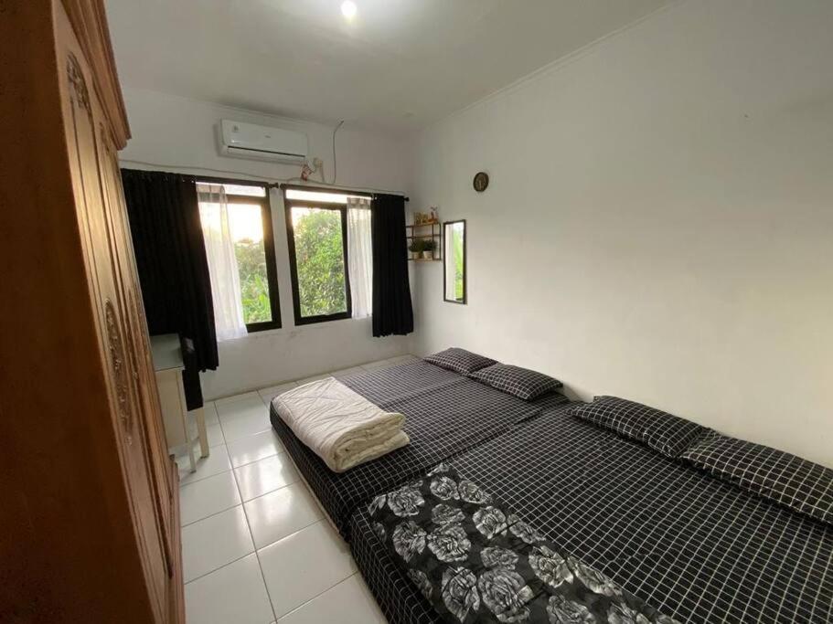 雅加达Coral House - Near Univ Indonesia Setu Babakan的一间卧室设有一张床和两个窗户。