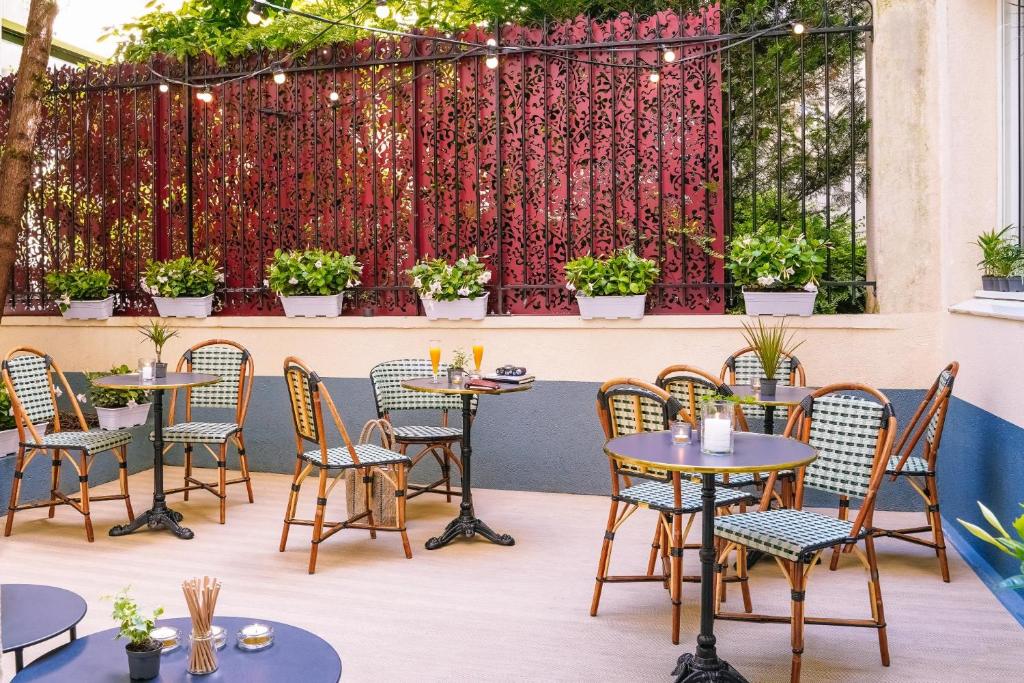 巴黎提姆埃菲尔铁塔酒店的一个带桌椅的庭院和种有植物的围栏