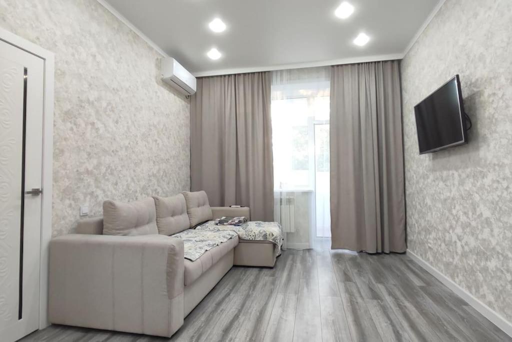 巴甫洛达尔Люкс апартаменты в ЖК Shanyrak的客厅配有白色沙发和电视