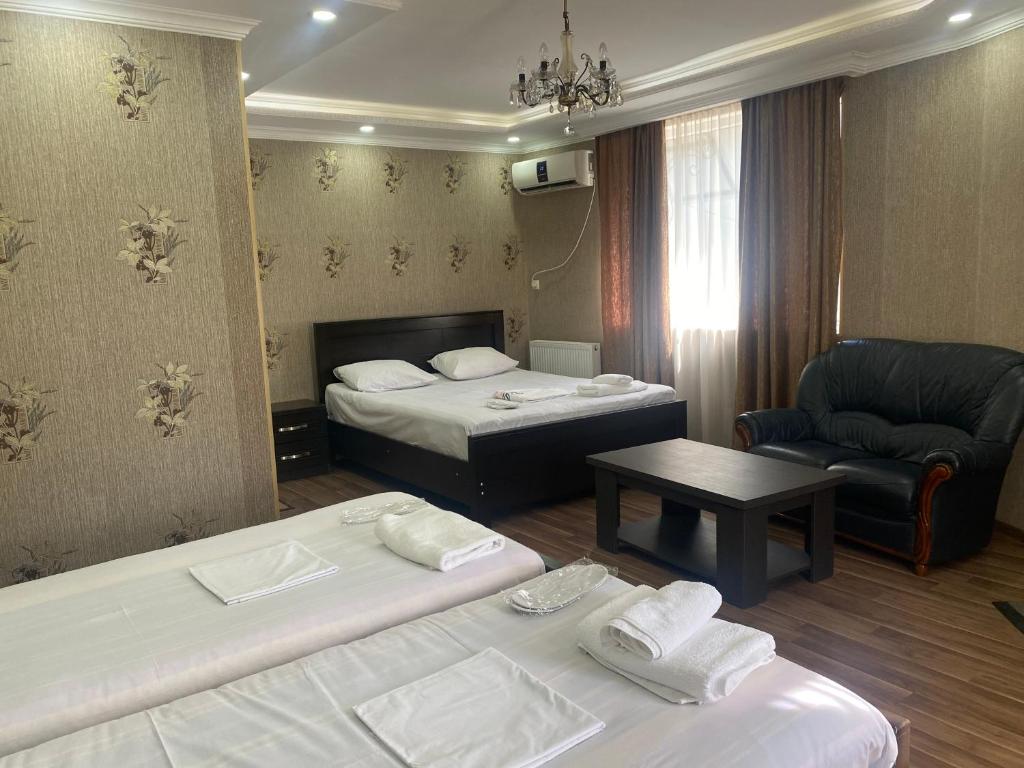 库塔伊西Hotel Mariana的酒店客房,配有两张床和椅子