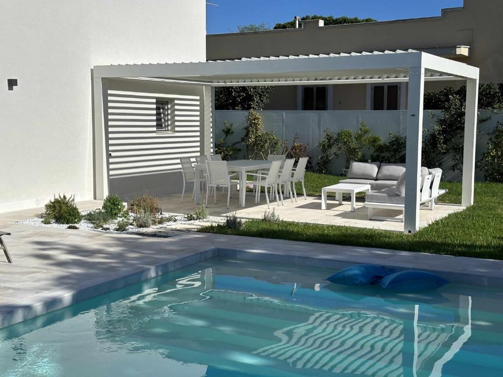Leporano MarinaCasa del Sol Luxury Estate Puglia的后院设有游泳池和桌椅
