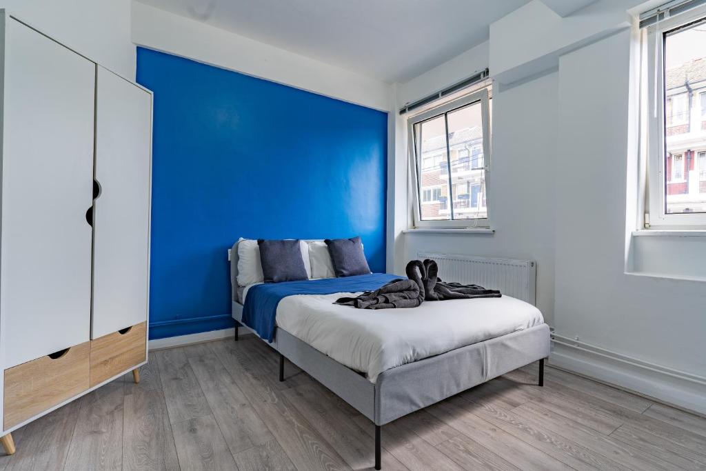 伦敦Bright 1 Bed Flat near London Bridge的一间卧室设有蓝色的墙壁和一张床