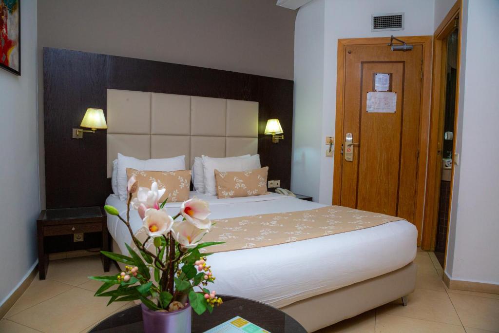 拉巴特马拉克酒店的一间卧室配有床和花瓶