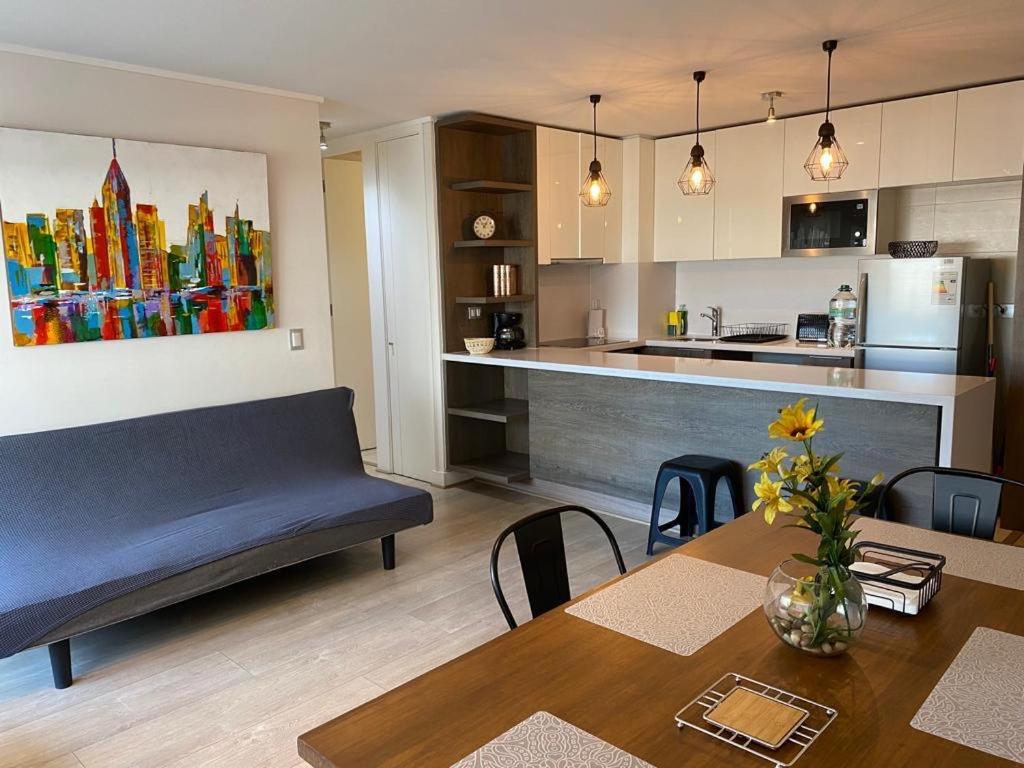 圣地亚哥Kennedy Premium Apartments的客厅以及带沙发和桌子的厨房。
