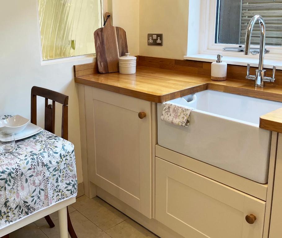 埃文河畔斯特拉特福Traditional 2 bedroom Cottage的厨房配有水槽和桌椅