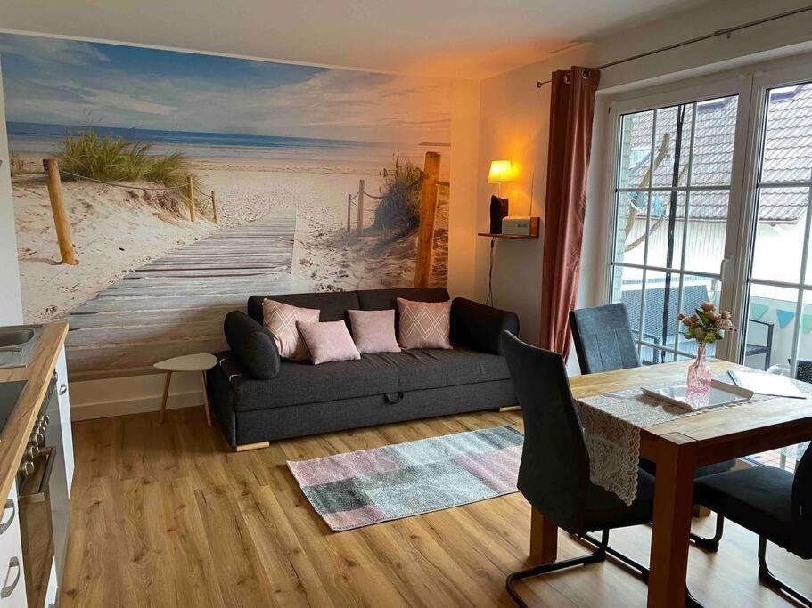 格洛米茨Kleines Glück Grömitz (ehemals Deichperle)的客厅配有沙发和海滩绘画