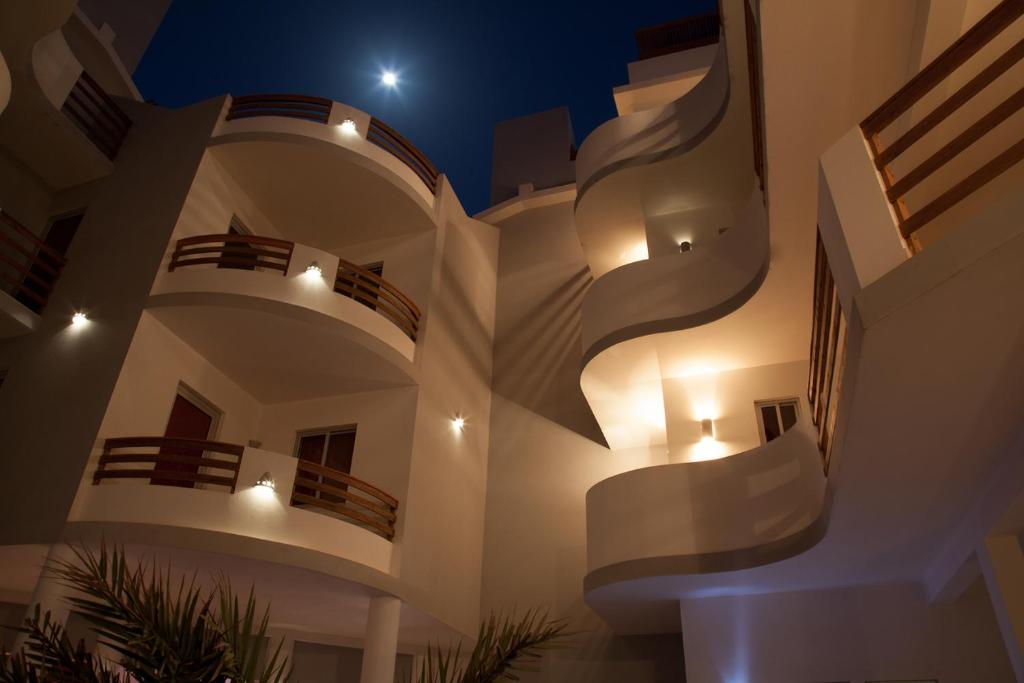 萨尔雷Cala da Lua apartments的一座大型白色建筑,晚上设有阳台