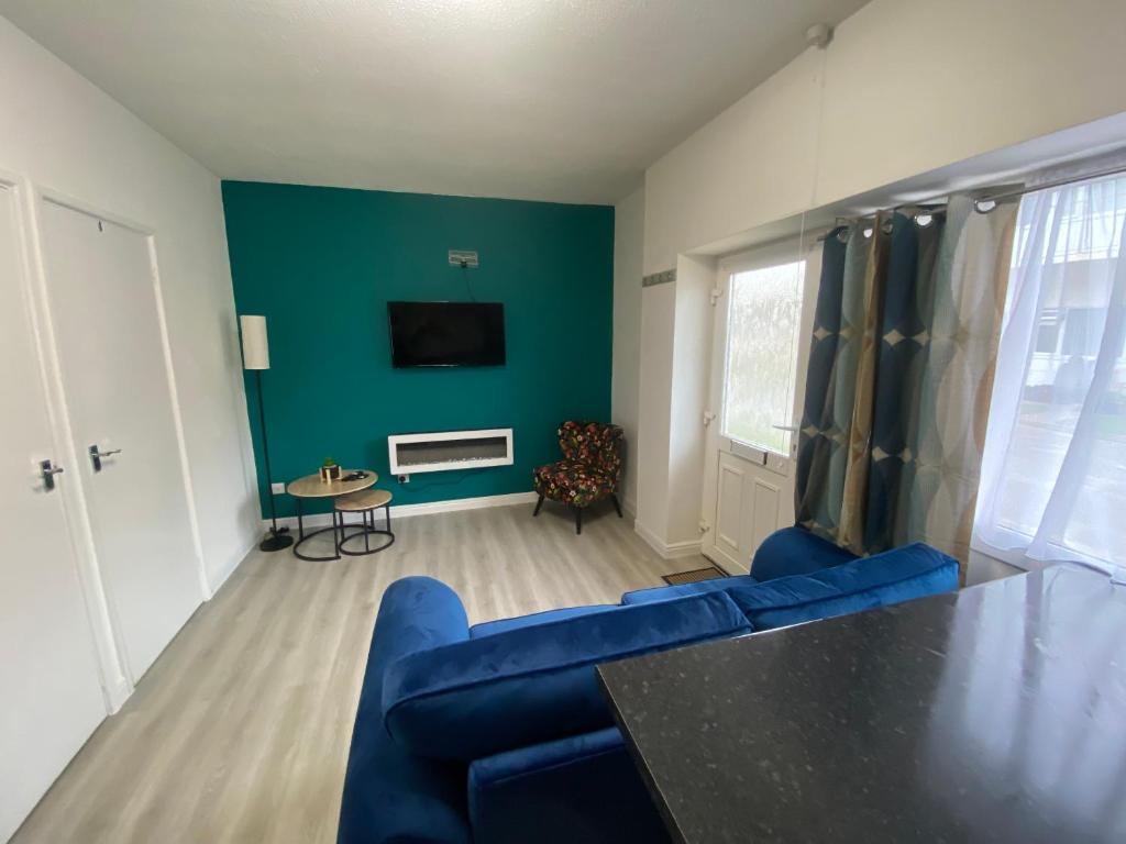 布里恩Ground floor apartment Brean的客厅配有蓝色的沙发和电视