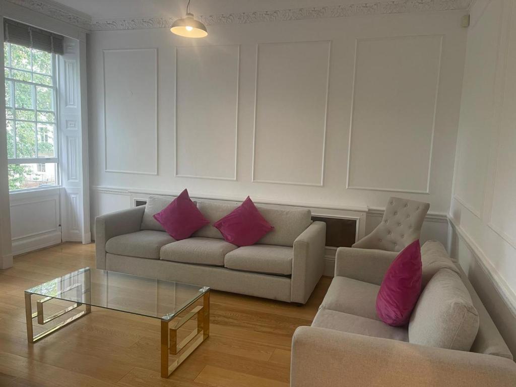 伦敦Kensington Luxury Apartments的客厅配有两张沙发和一张玻璃桌