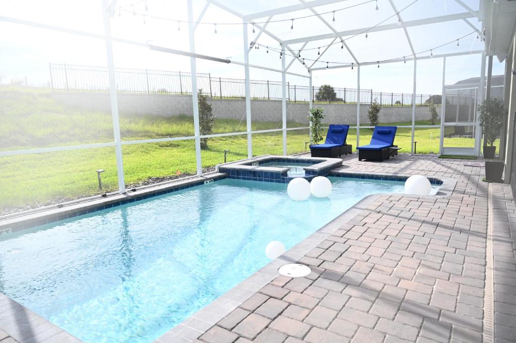 基西米Luxurious 8-Room Oasis near Disney的一个带2把蓝色椅子的游泳池