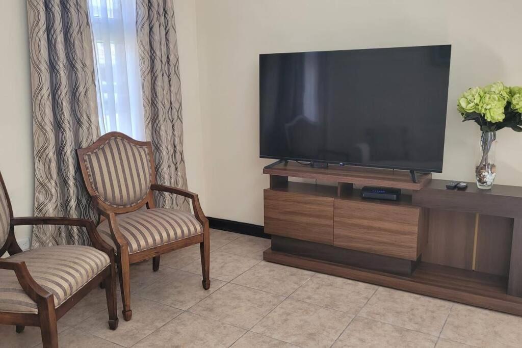 克萨尔特南戈Casa en condominio的客厅配有平面电视和2把椅子