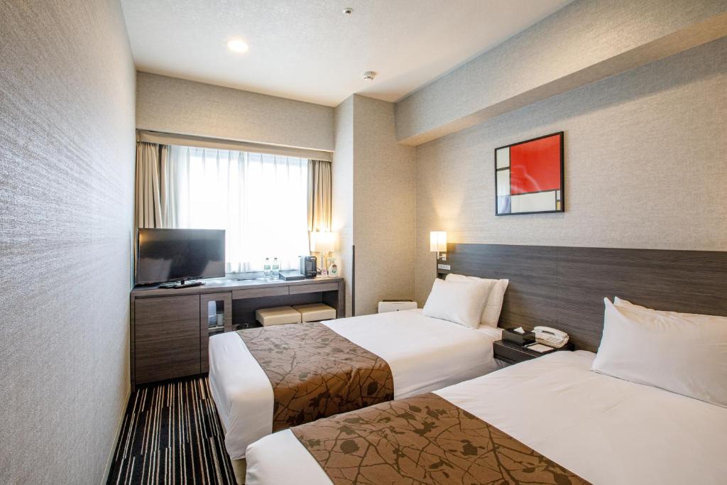 福知山福知山太阳道酒店的酒店客房设有两张床和电视。