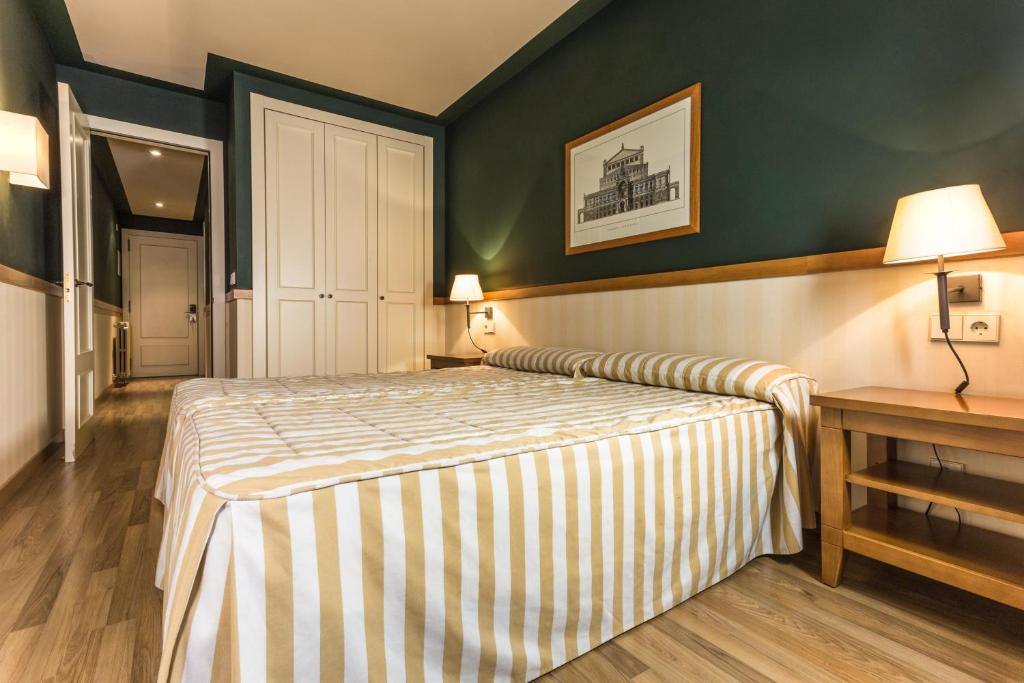 恩坎普Apartaments Shusski的酒店客房配有一张床铺和一张桌子。
