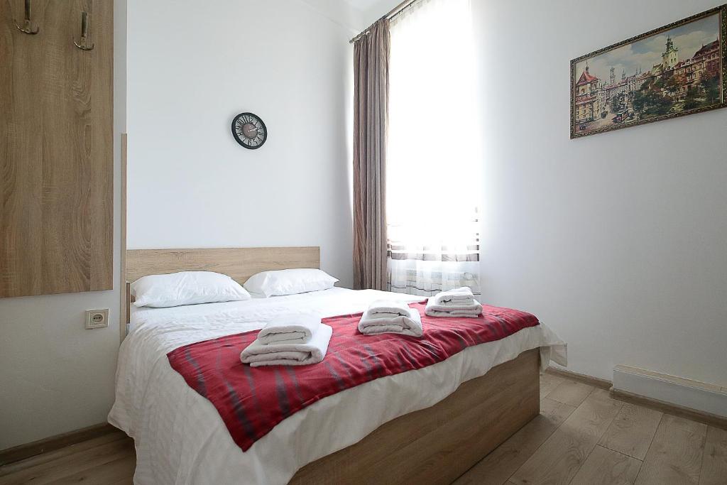 利沃夫Deluxe Apartments on Doroshenka 29的一间卧室配有一张大床和毛巾