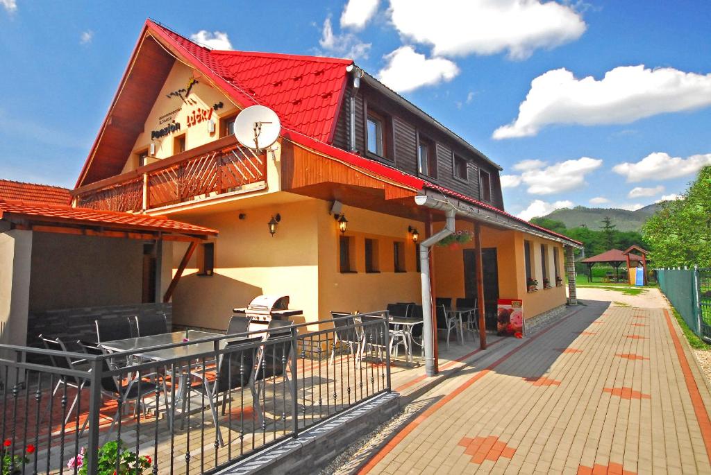 卢奇基Penzión Lúčky的一座带红色屋顶和庭院的房子
