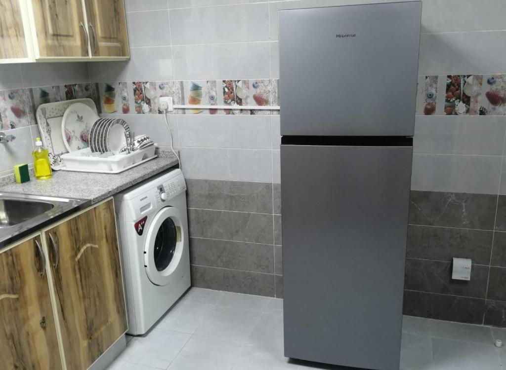 阿吉曼Al Rawda Apartments -Ajman的厨房配有洗衣机和水槽