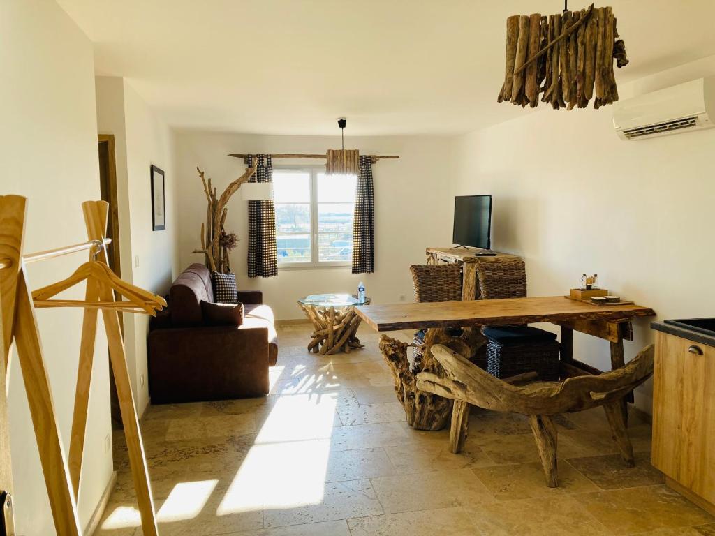 圣马迪拉莫Manade des Baumelles的客厅配有木桌和沙发