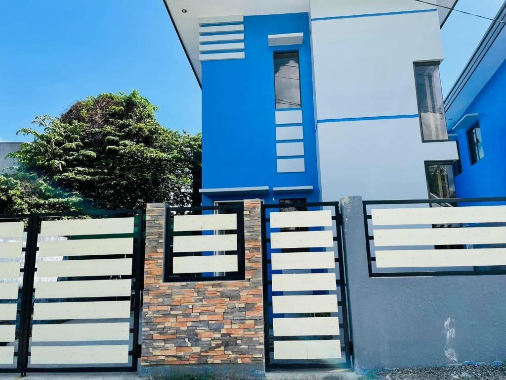 伊洛伊洛Marc louie estiaga home for rent的白色的蓝色房屋,设有白色的围栏