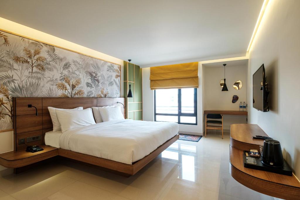 斋浦尔Indie Stays Jaipur的卧室配有一张白色大床和一张书桌
