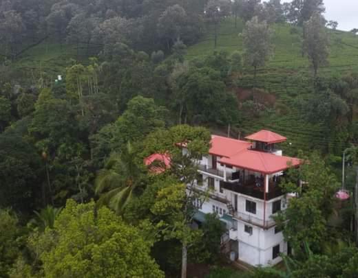 康提Villa 95 Rangala的森林中间有红色屋顶的房子