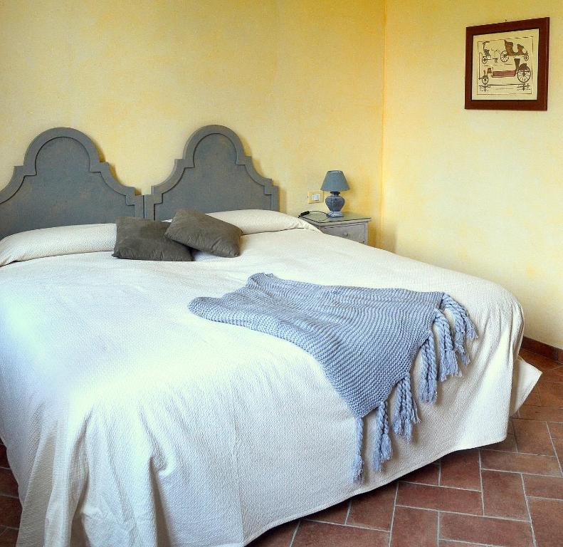 巴斯基里奥Agriturismo Borgo San Francesco的一间卧室配有一张大白色床和蓝色毯子