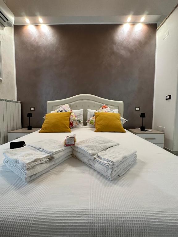 泰尔莫利B & B Via Cavour的一张白色大床,上面有黄色枕头