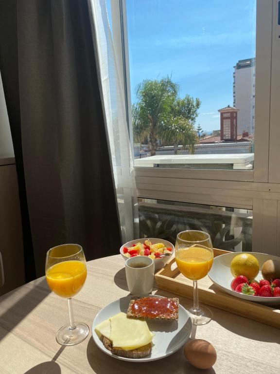 多列毛利诺斯Studio La Carihuela的一张桌子,上面放着一盘食物和两杯橙汁