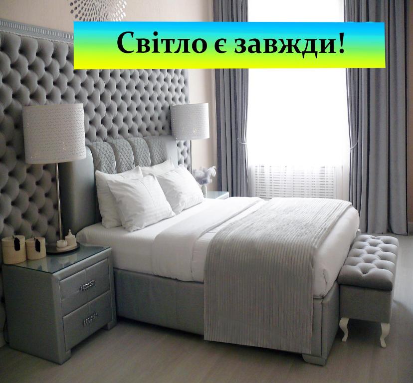 基辅Luxury Centre Located Apartment的一间卧室配有一张大床和一把椅子