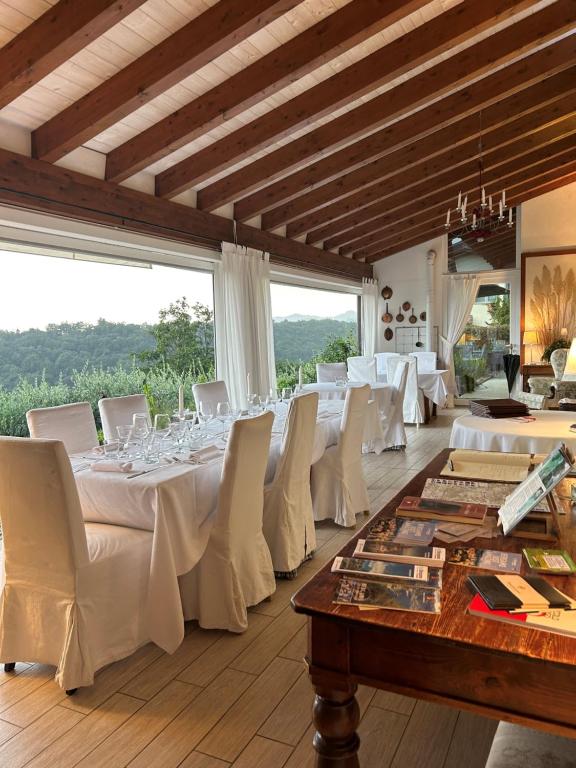 阿尔蒙诺圣巴特鲁姆Agriturismo Al Robale的用餐室配有白色的桌子和白色的椅子