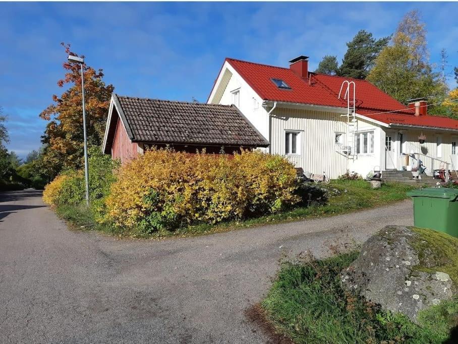 Yö Vaahteramäellä的路边有红色屋顶的白色房子