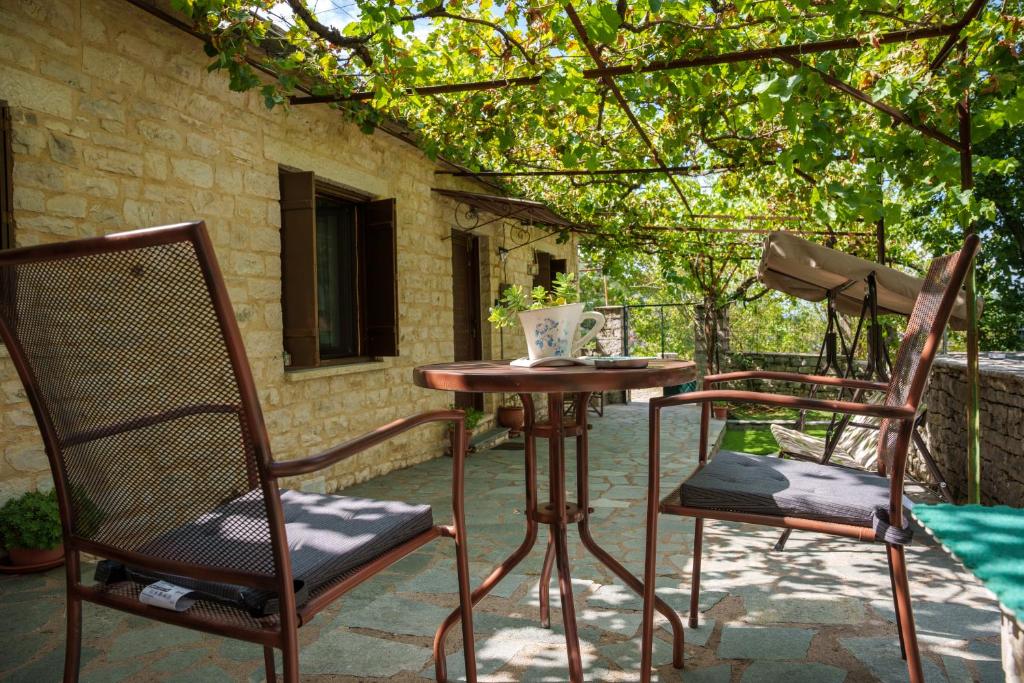 阿里斯蒂Euaggelias & Cristianas House的庭院里设有两把椅子和一张桌子