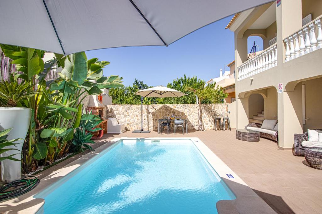 阿尔布费拉Private Deluxe 3BD Villa Pool Wi-Fi AC BBQ的一座带遮阳伞的别墅内的游泳池