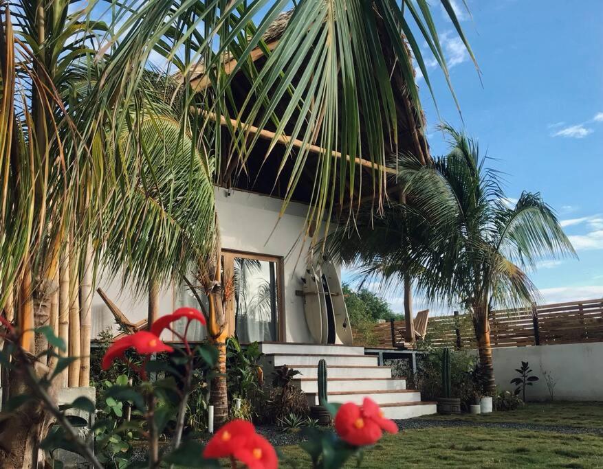 波波约Jungle Shacks : Hoku Casita的前面有棕榈树的房子