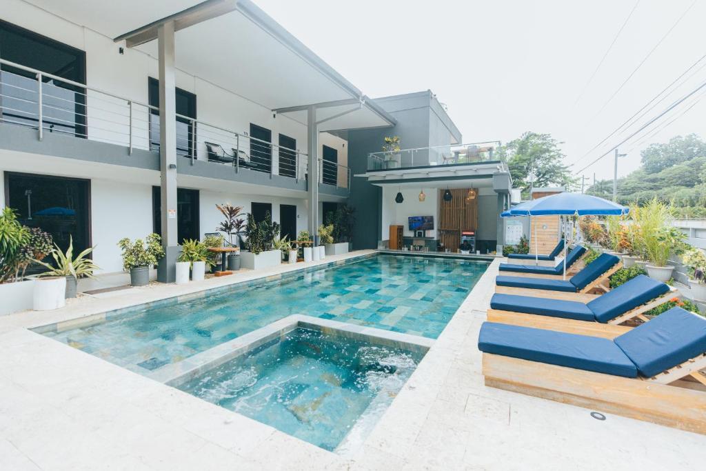 赫拉多拉Paradise Bay Hotel Boutique的一座带蓝色躺椅的游泳池的房子