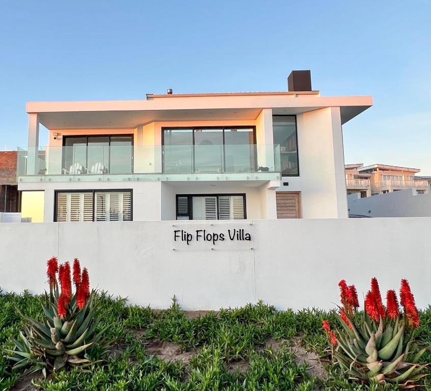 伊泽芳登Flip Flops Villa的墙上有红花的房子