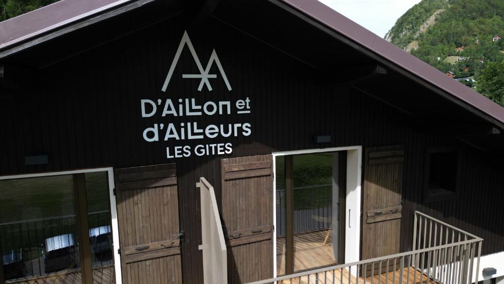 Aillon-le-JeuneLes Gîtes d'Aillon et d'Ailleurs的一座黑色的建筑,旁边有一个标志