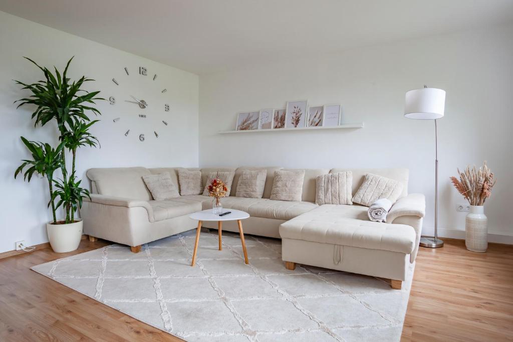 汉诺威Exclusive 2-Room-City-Apartment - Contactless Check-in的客厅配有沙发和墙上的时钟