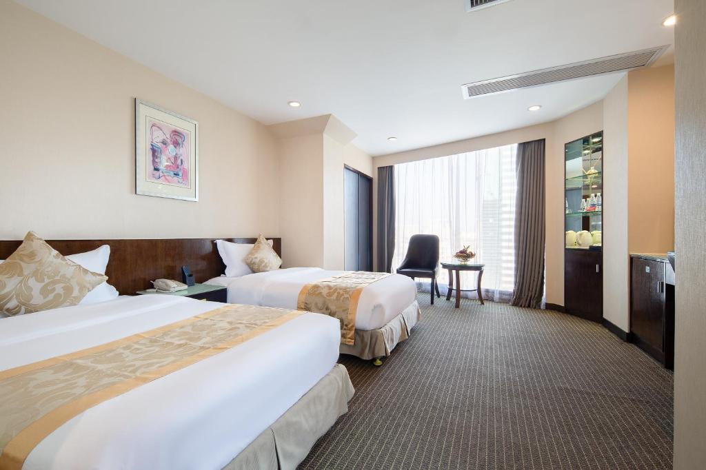 广州广州颐和商务酒店的酒店客房配有两张床和一张书桌