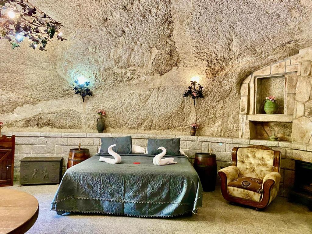 拉卡布雷拉Cueva romántica - Jacuzzi的一间卧室,卧室配有一张床上的2个天鹅和一把椅子