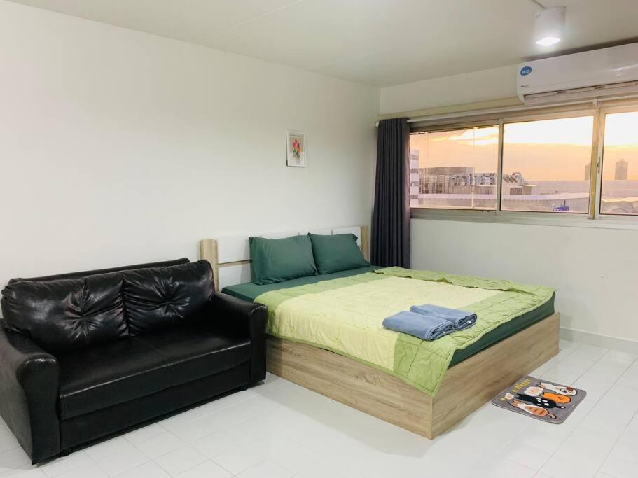 Thung Si KanCondo popular T8 fl.12的一间卧室配有一张床和一张黑色皮椅