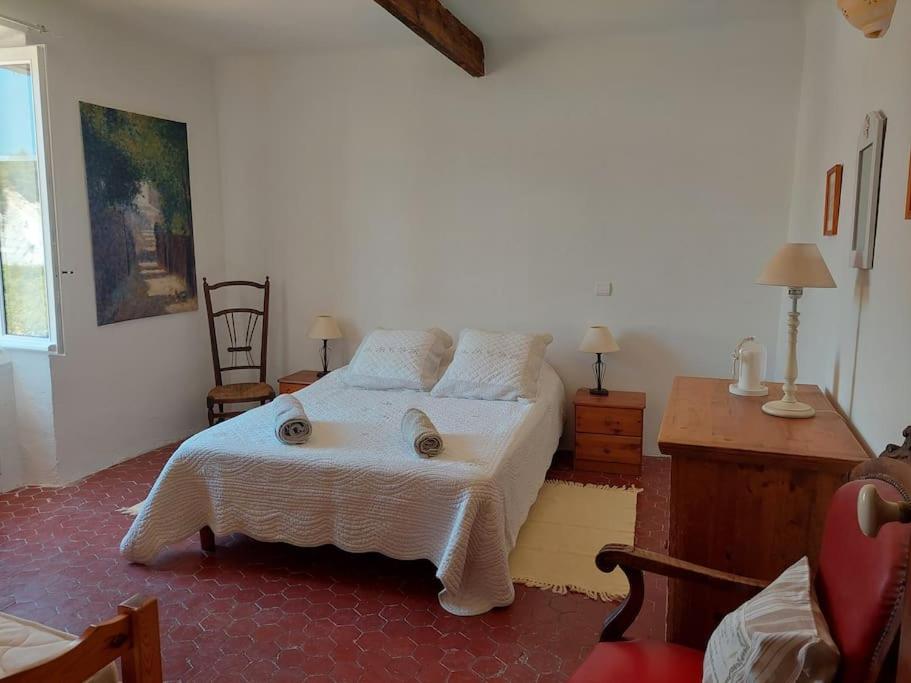 圣萨蒂南艾普特Maison de César的一间卧室配有一张带白色床罩的床