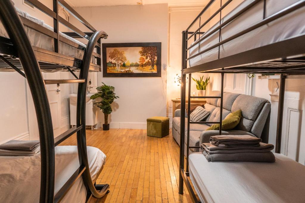 魁北克市Auberge de la paix的客房设有两张双层床和一张沙发。