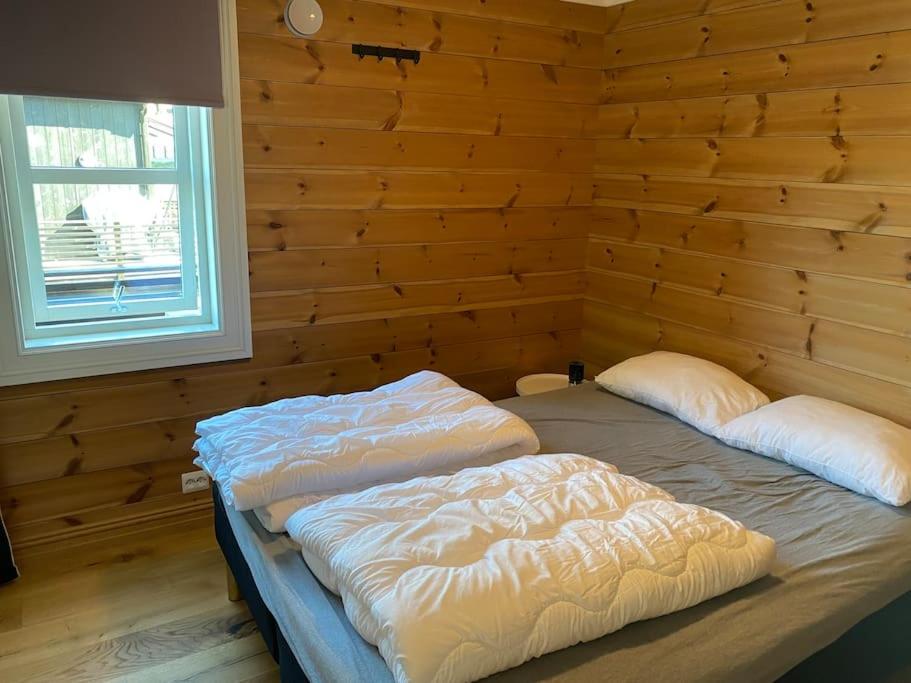 斯特兰达Hytteleilighet på Strandafjellet的木墙客房的两张床