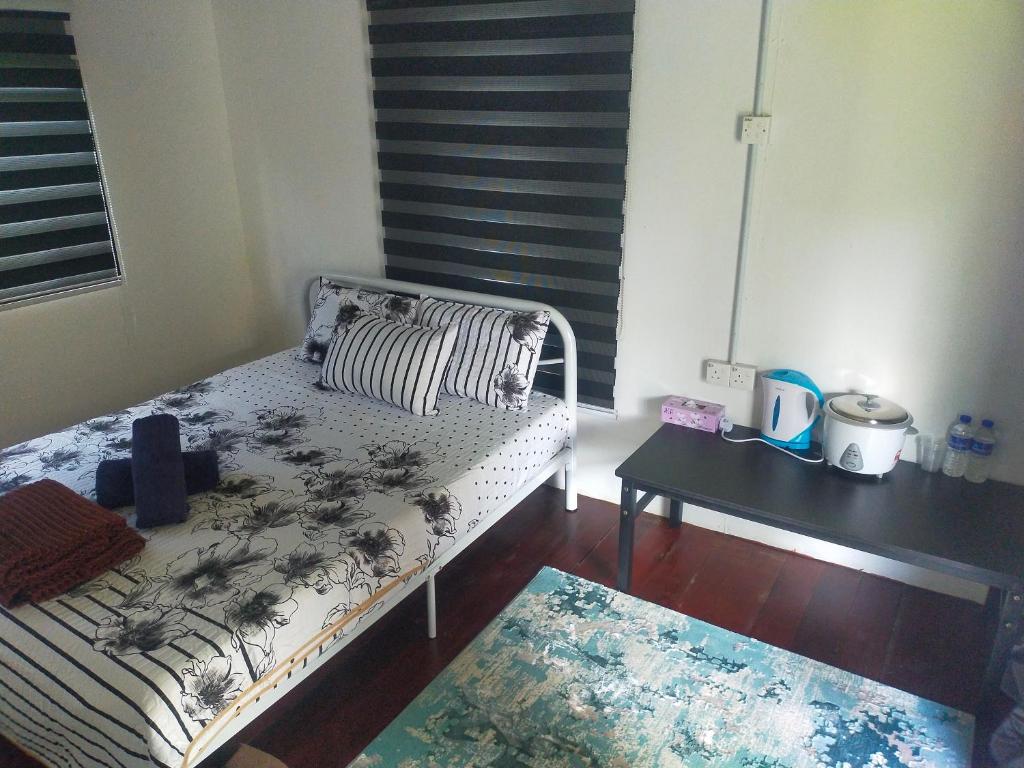 Kuala KeraiDusun Rimbun Agro Farmstay 3的一间小卧室,配有一张床和一张桌子