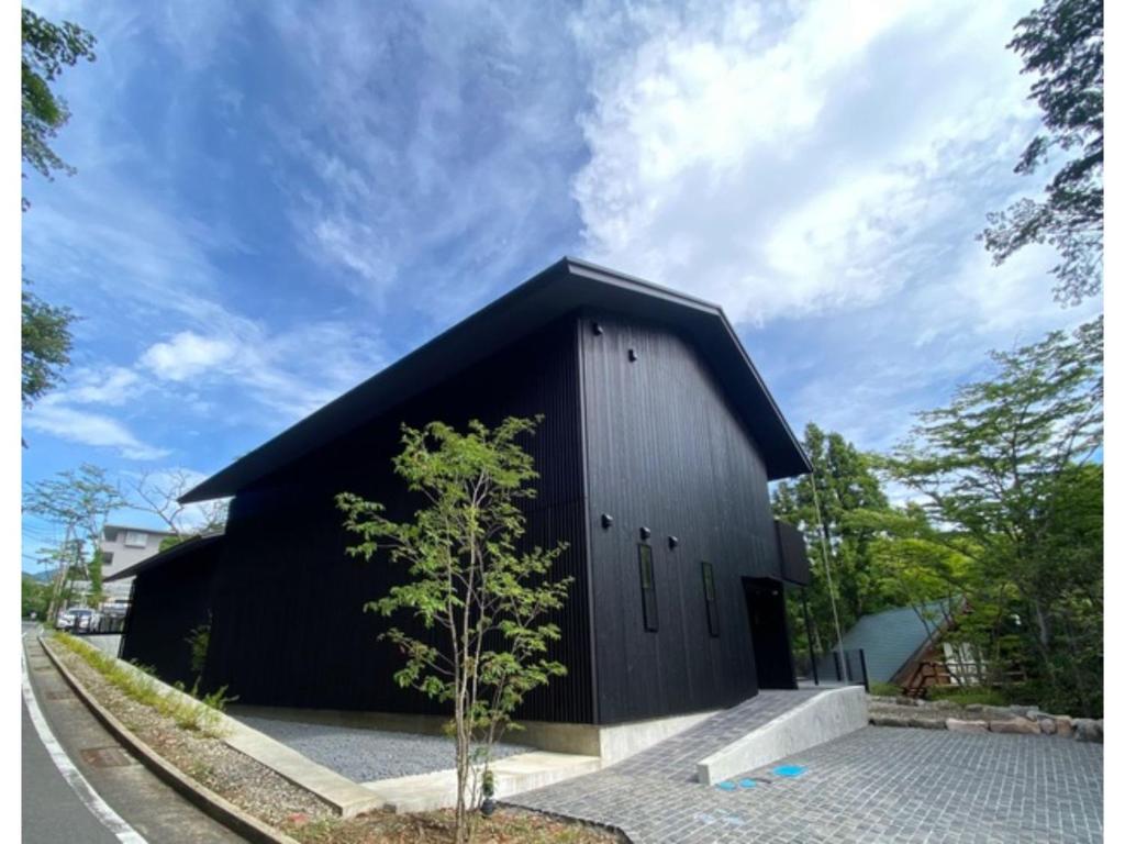 OnsensōMONS GORA - Vacation STAY 68017v的前面有一棵小树的黑色建筑