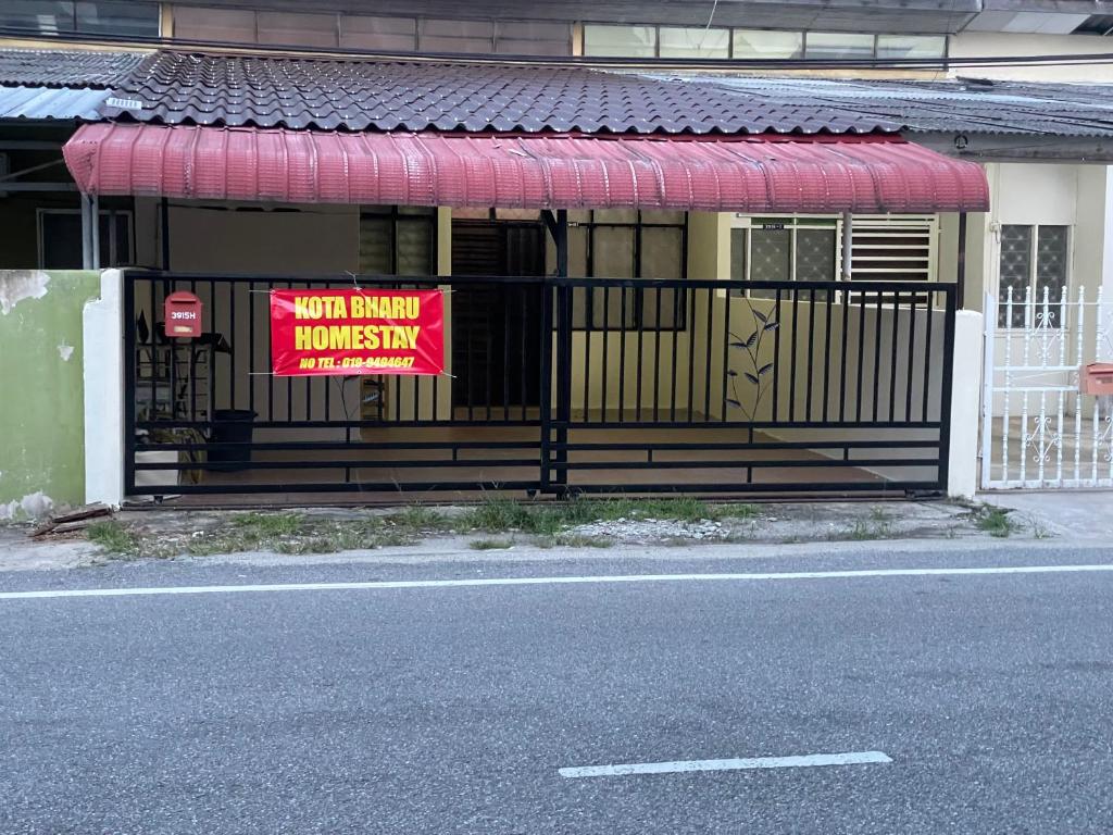 哥打巴鲁Kota Bharu Homestay的房屋前门上的标志