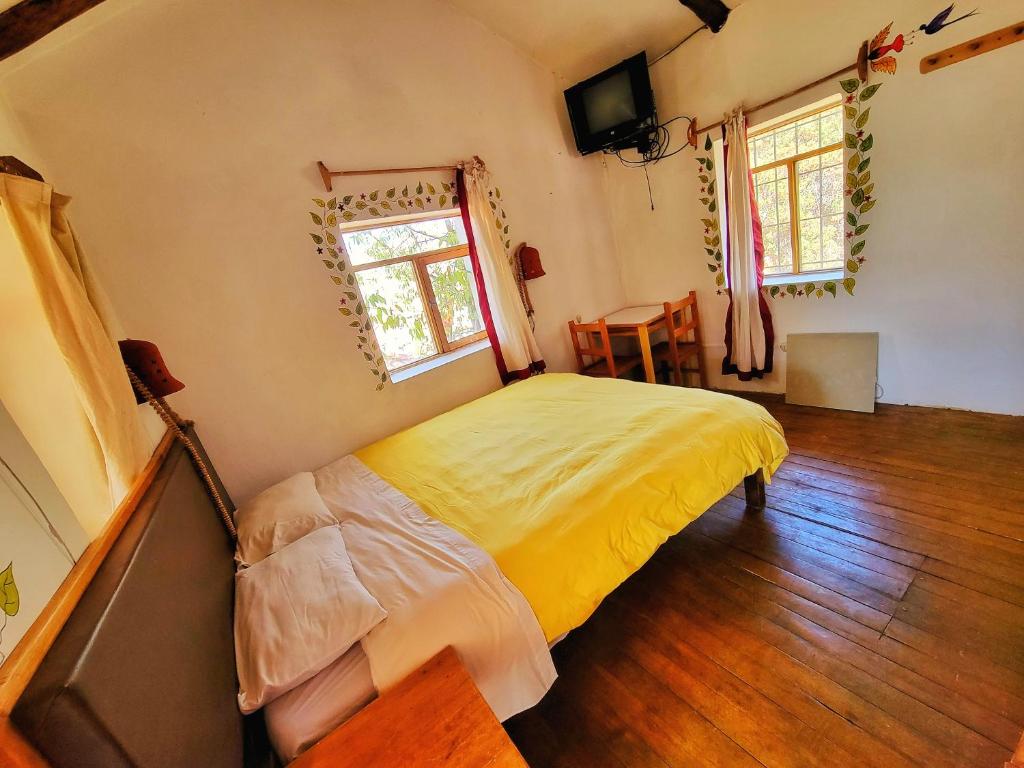 库斯科La Casa de Campo的一间卧室配有一张床、一张桌子和一个窗户。