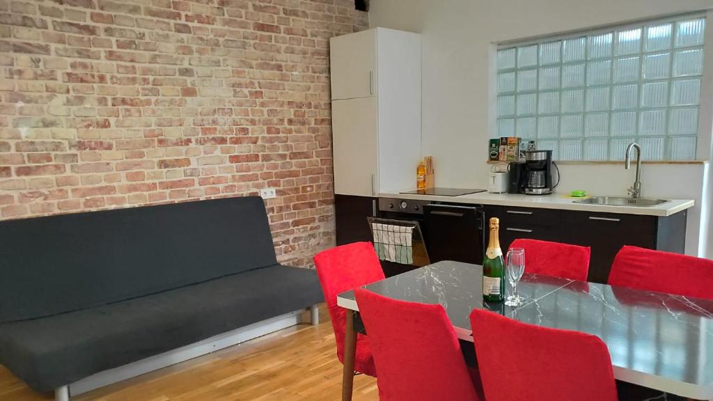 维也纳CozyNite Premium Apartment Stadthalle的厨房配有红色椅子和沙发