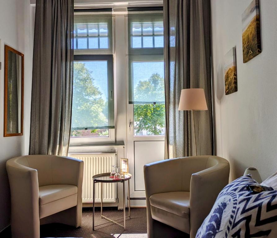 吕贝克瑞士屋酒店 的一间卧室配有两把椅子、一张床和窗户