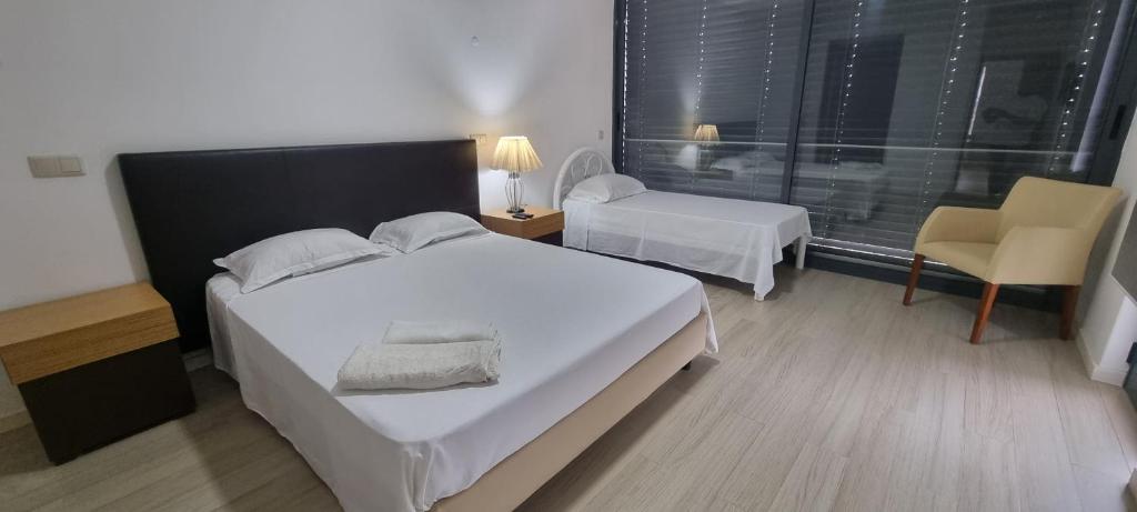 普拉亚Kriol Guest House的卧室配有一张白色大床和一把椅子